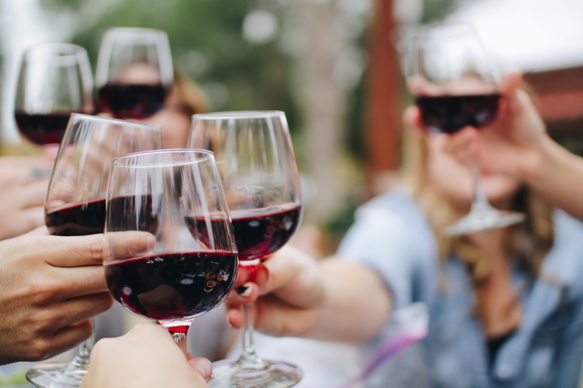 Friends raising glasses of red wine together in a toast